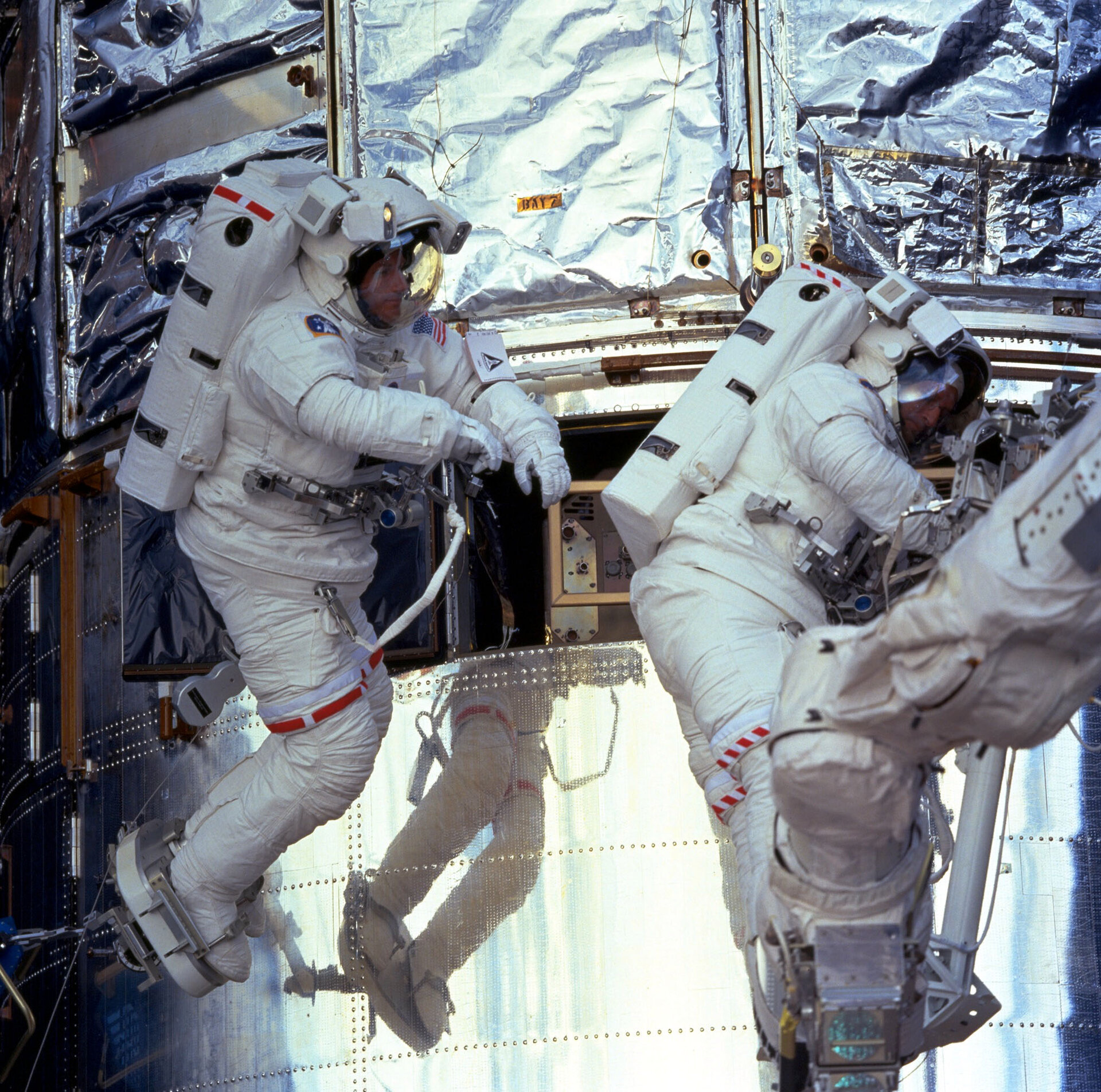 Astronauts on spacewalk during Hubble servicing