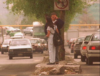 At a Mexico City intersection, an unidentified man rubs his eyes as the couple waits to cross the traffic