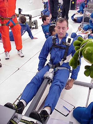 Former ESA astronaut Philippe Perrin assesses the Flywheel Exercise Device during a parabolic flight