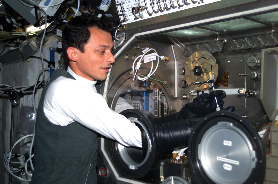 ESA astronaut Pedro Duque using the Microgravity Science Glovebox during the Cervantes Mission