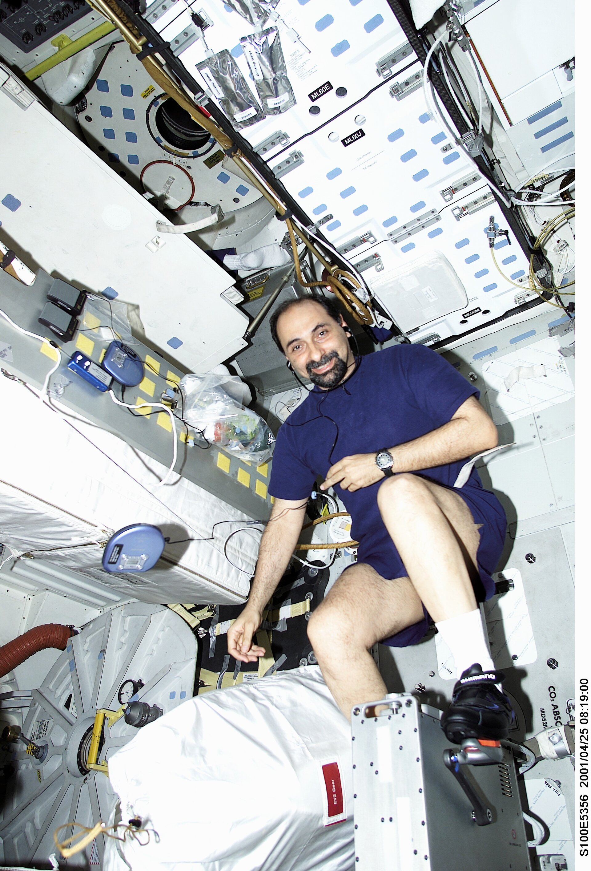 ESA astronaut Umberto Guidoni working out on a bicycle ergometer onboard the Space Shuttle