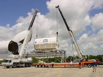 Two cranes lower the Columbus laboratory toward a flatbed truck