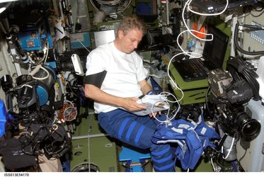 Thomas Reiter looks over a procedures checklist in the ISS Zvezda Service Module