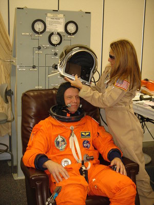 Christer Fuglesang is helped into his orange Advanced Crew Escape Suit (ACES) in preparation for the practice countdown