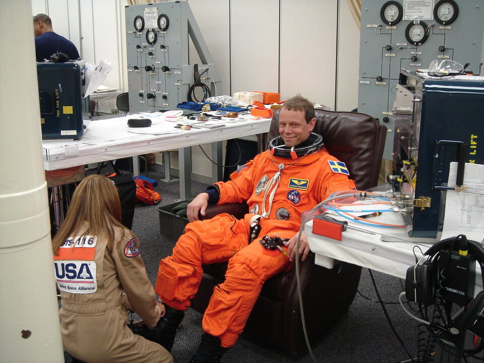 Christer is helped to dress in the orange spacesuit
