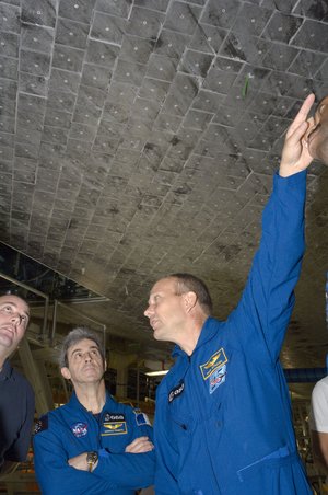 ESA astronauts Leopold Eyharts and Hans Schlegel during inspection of Space Shuttle Atlantis at KSC, Florida
