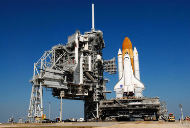 Platforms are extended toward Space Shuttle Atlantis