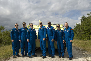 STS-122 crew pose next to an emergency evacuation vehicle at Kennedy Space Center, Florida