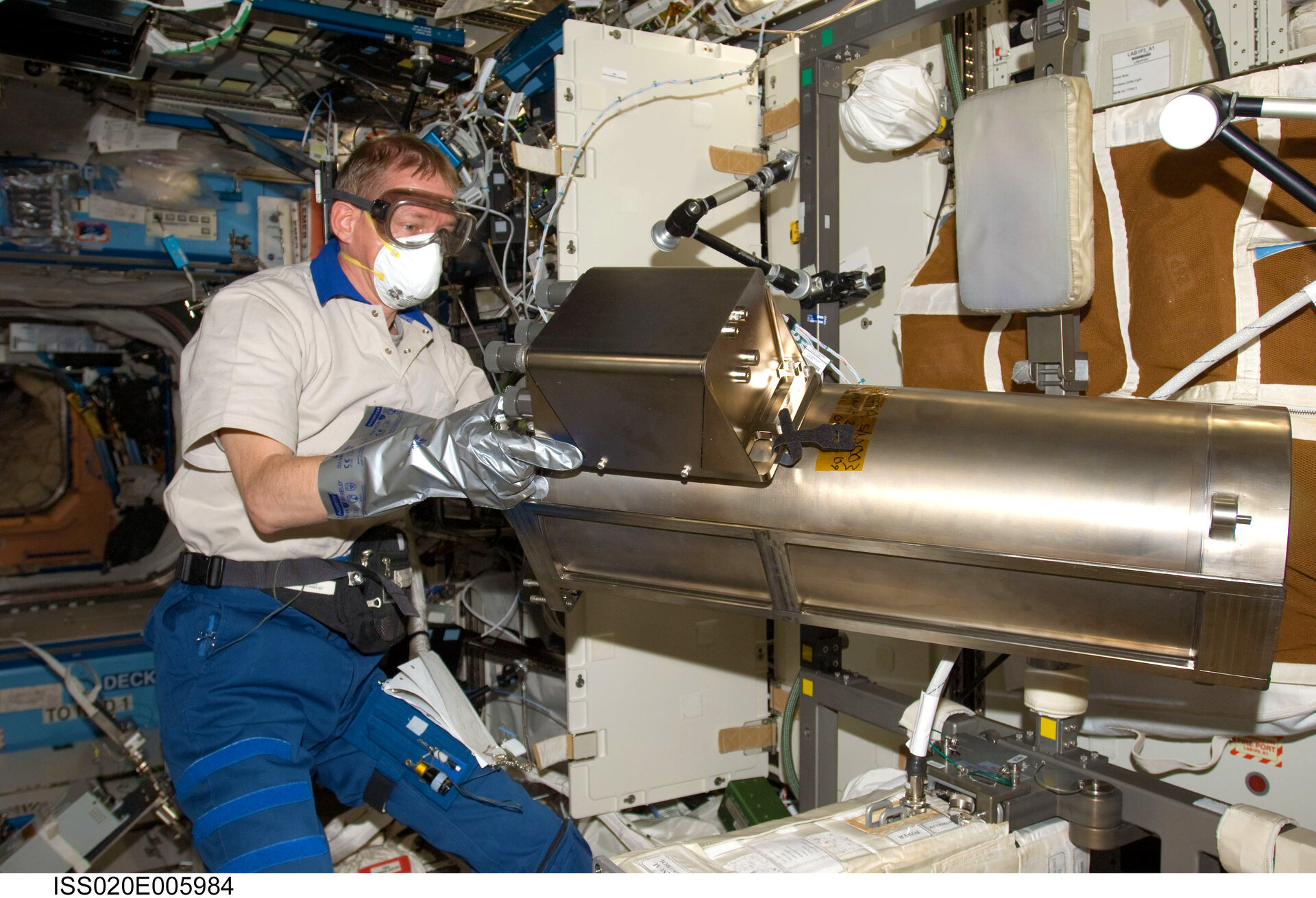 L'astronaute de l'ESA Frank De Winne au travail dans la station spatiale internationale pendant son séjour dans l'espace en 2009, ici avec un système de recyclage de l'eau 