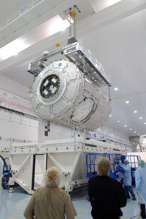Node 3 is lowered towards a work stand in the Space Station Processing Facility at KSC