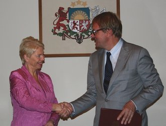 Latvian Minister for Education and Science, Tatjana Koke, and ESA’s Peter Hulsroj sign the Cooperation Agreement