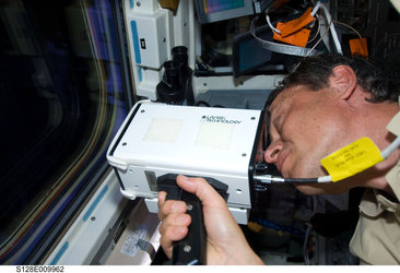Christer Fuglesang uses handheld laser ranging device after undocking of Discovery from ISS