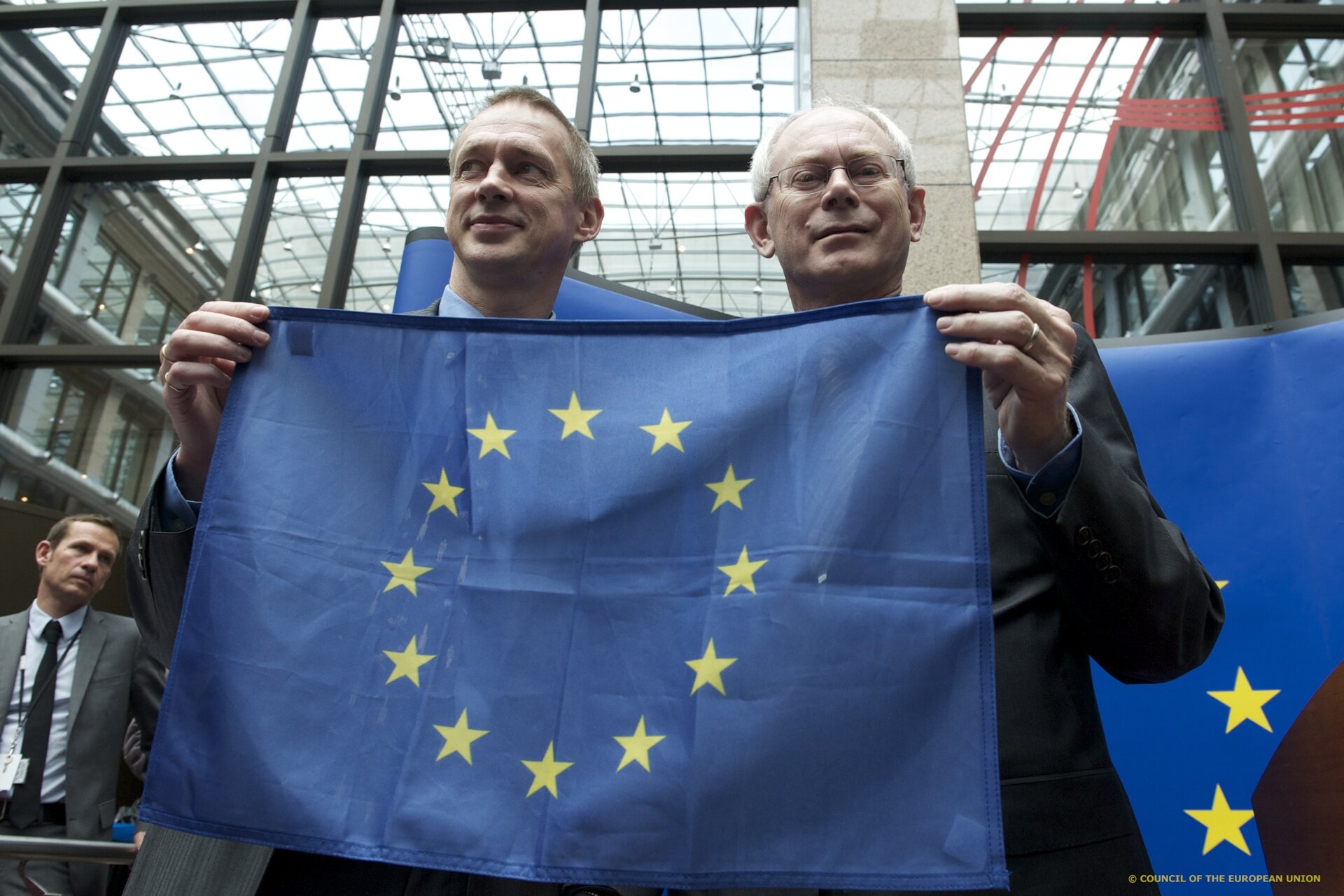 Frank De Winne and Herman van Rompuy with a spacefaring EU flag