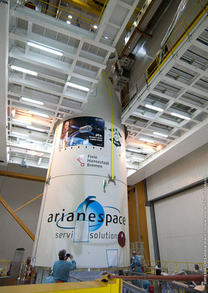 Aerodynamic fairing being lifted by crane over top of ATV-3 in Kourou