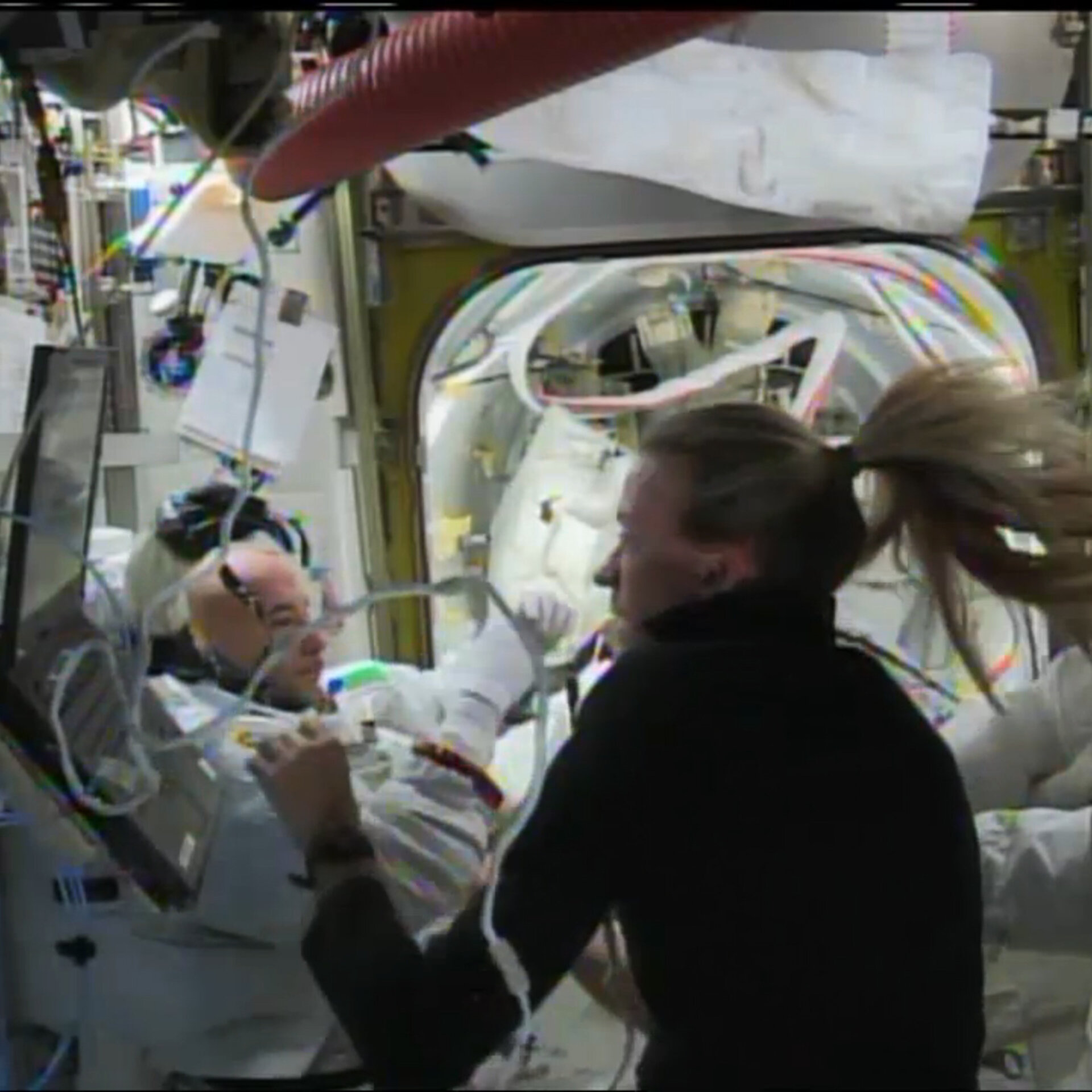 NASA astronaut Karen Nyberg helps Luca Parmitano remove his helmet and suit