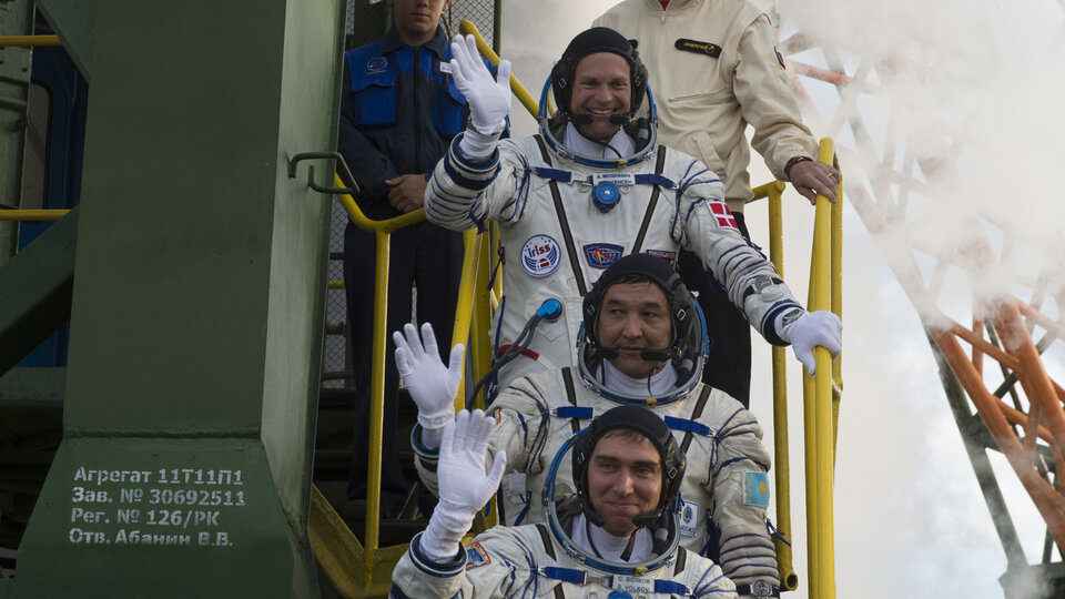 Soyuz TMA-18M crew members greeting audience at the launch pad