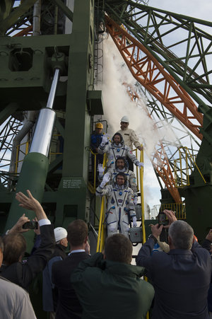 Soyuz TMA-18M crew members greeting audience at the launch pad