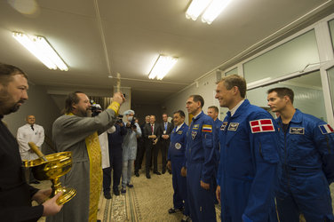 Crew members receive the traditional blessing from a Russian Orthodox priest