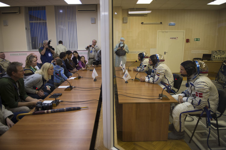 Soyuz TMA-18M crew members talking to gathered friends, family and dignitaries