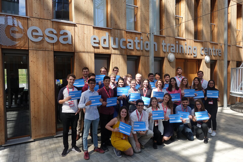 Students posing under the brand-new ESA Education Training Centre logo