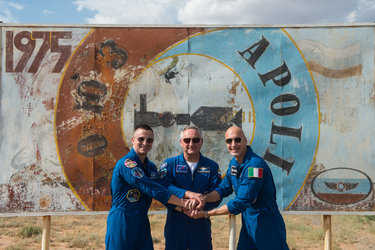 Expedition 60 crewmembers in front of a mural of the 1975 Apollo-Soyuz mission