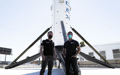 ESA astronauts Matthias Maurer and Thomas Pesquet stand in front of a SpaceX rocket